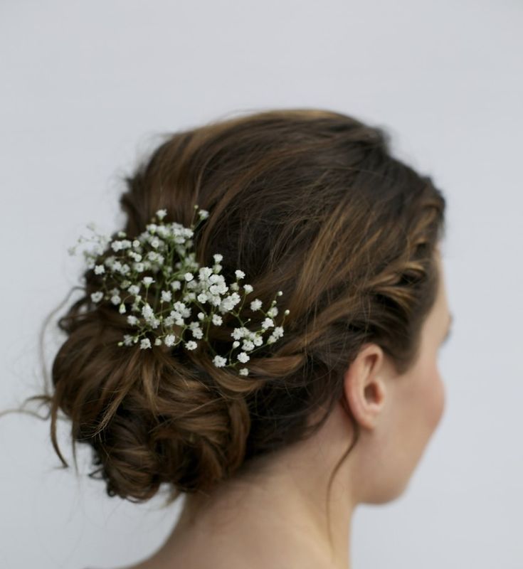 a woman wearing a bridal hair piece with baby's breath