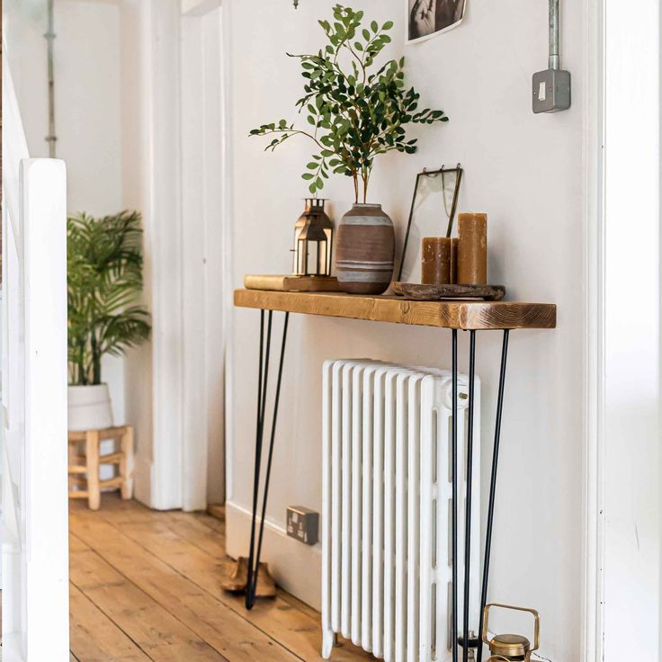 a shelf with some plants on top of it next to a wall mounted radiator