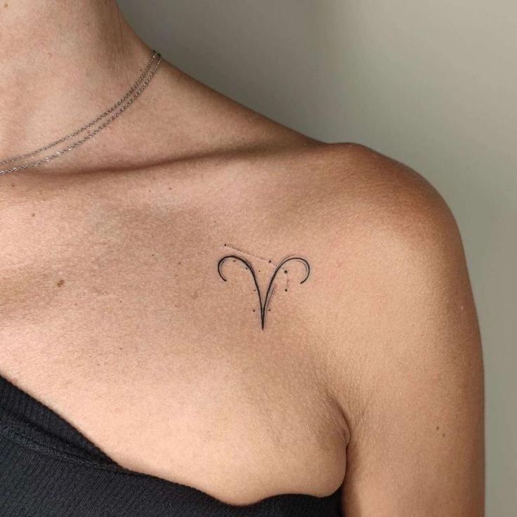 a woman with a tattoo on her chest is looking at the camera and has an arrow in it