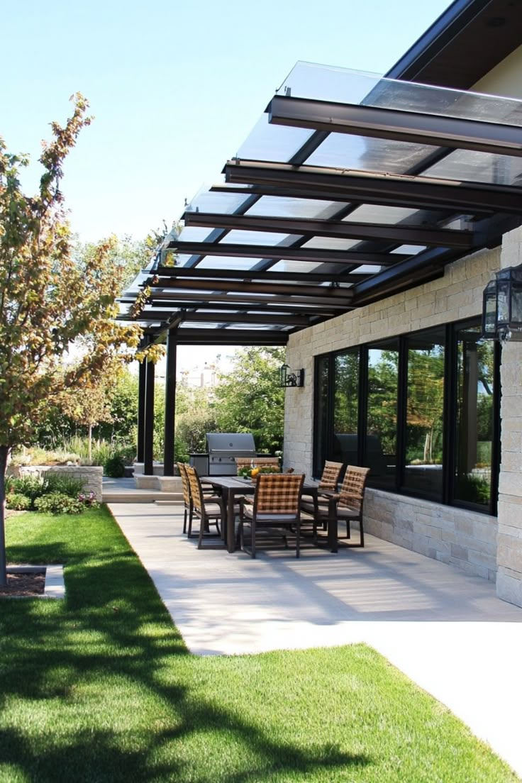 Modern outdoor patio with a glass pergola, dining table set, and a grill. Cheap Patio Cover, Patio Cover Retractable, Patio Retractable Shade, Retractable Glass Roof Patio, Retractable Pergola Canopy Waterproof, Patio Cover Ideas, Metal Pergola With Retractable Canopy, Diy Patio Cover, Green Roof System