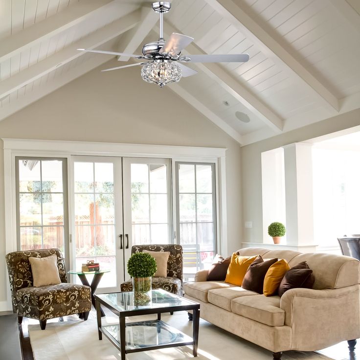 a living room with couches, chairs and a ceiling fan in it's center