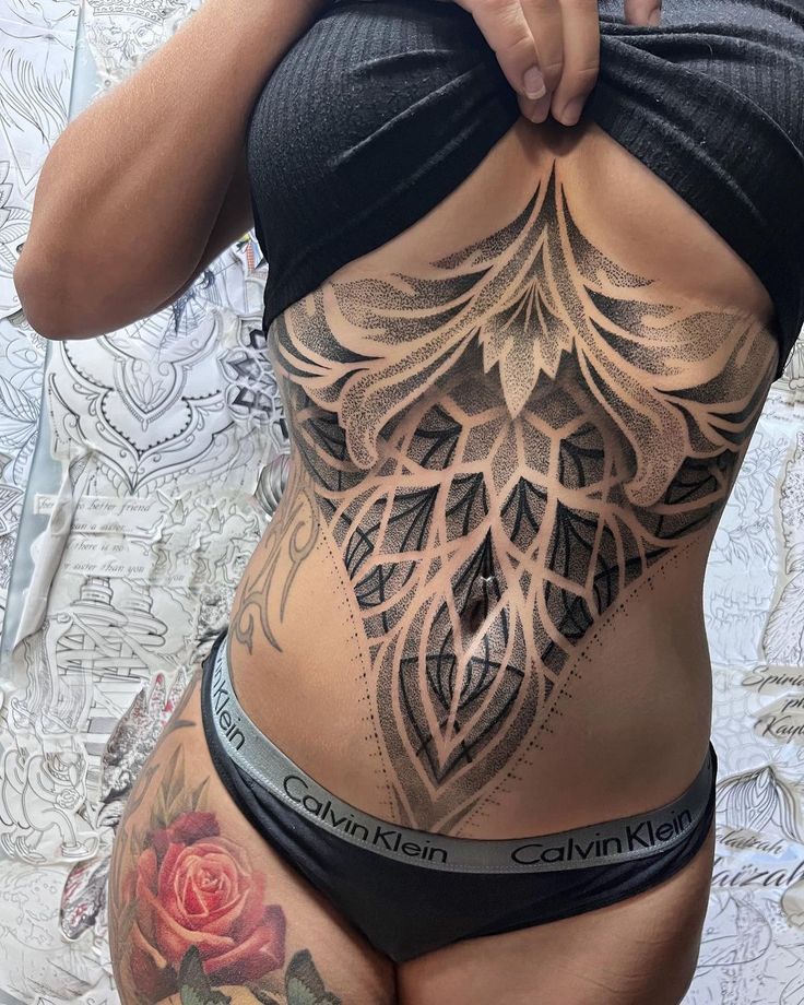 a woman with tattoos on her stomach and back