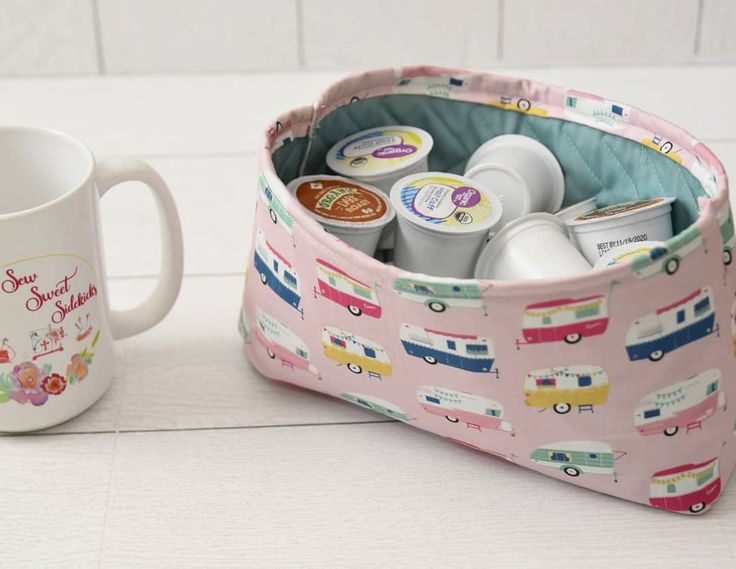 a coffee cup and mug holder with various items in it on a white counter top