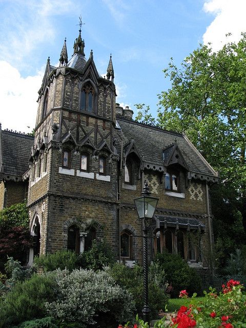 an old building with flowers and trees around it