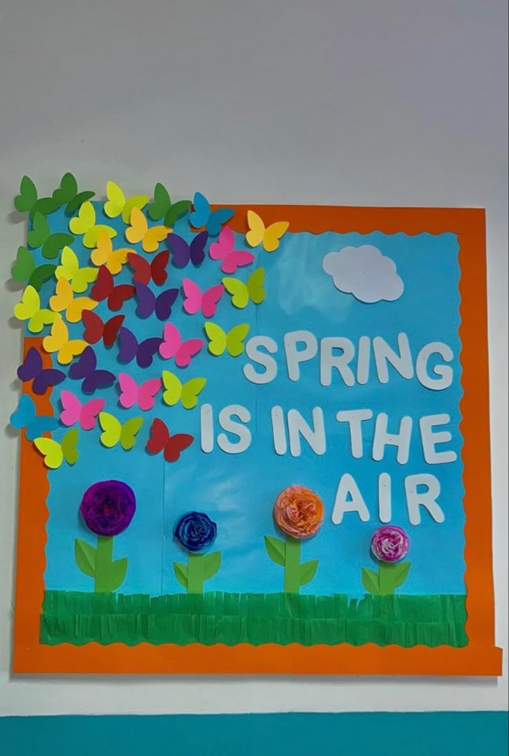 a bulletin board with paper flowers and butterflies on it that says spring is in the air