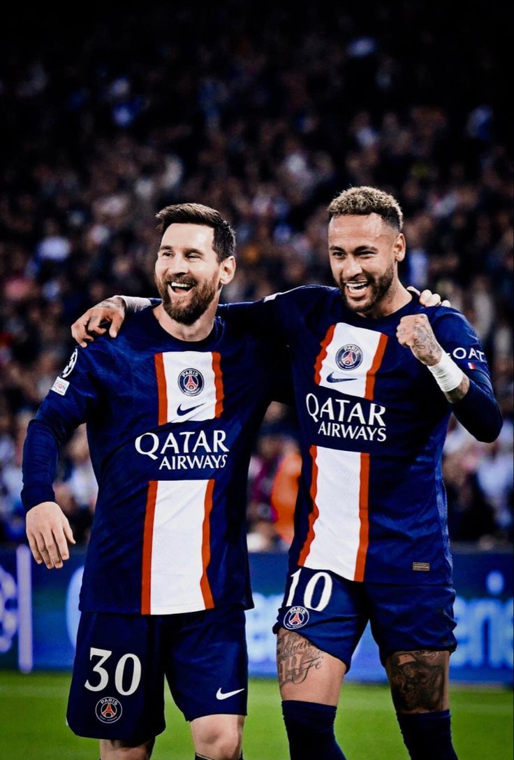 two men standing next to each other on a soccer field