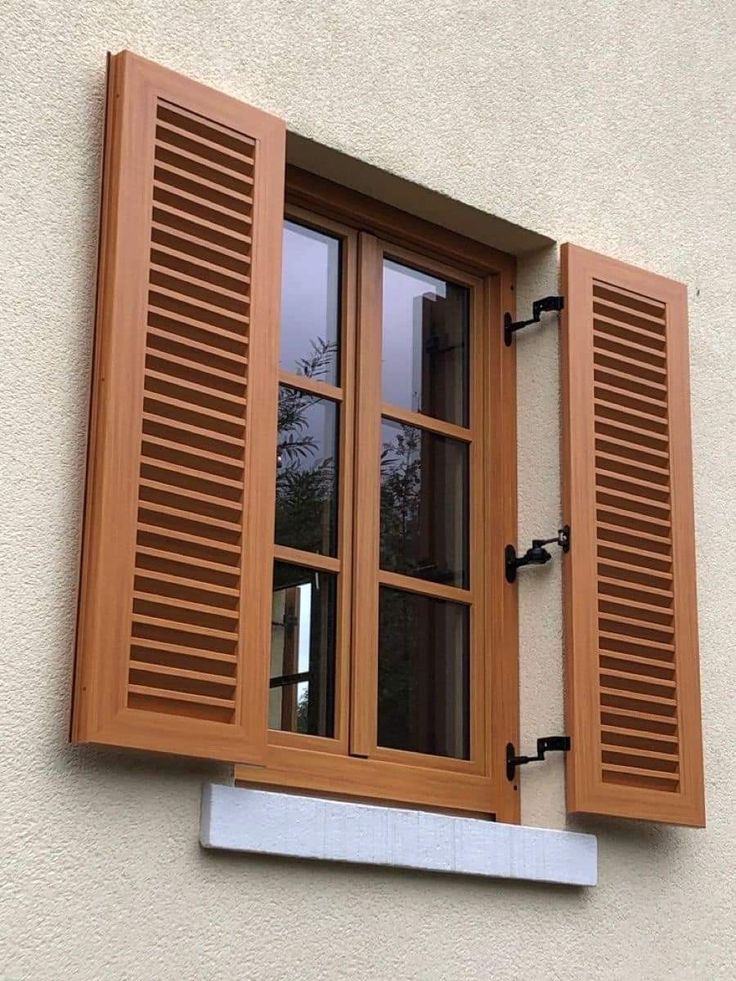 an open window with wooden shutters on the outside