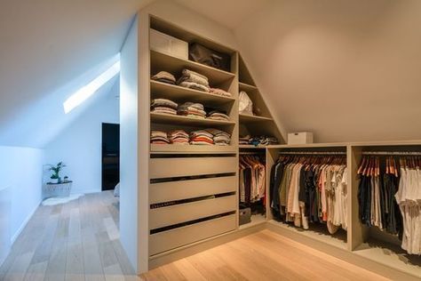 an attic bedroom with closets full of clothes