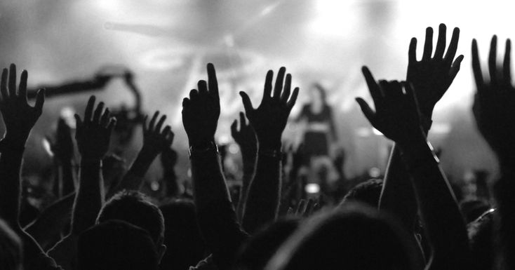 people raising their hands in front of a stage with the words haleluah on it