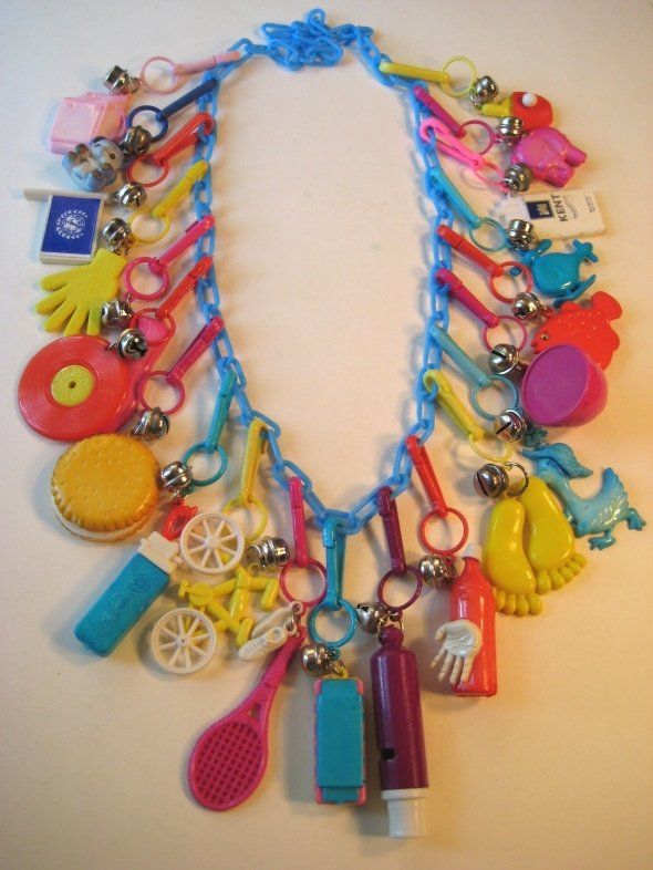 a necklace made out of various items on a white table with scissors and other accessories