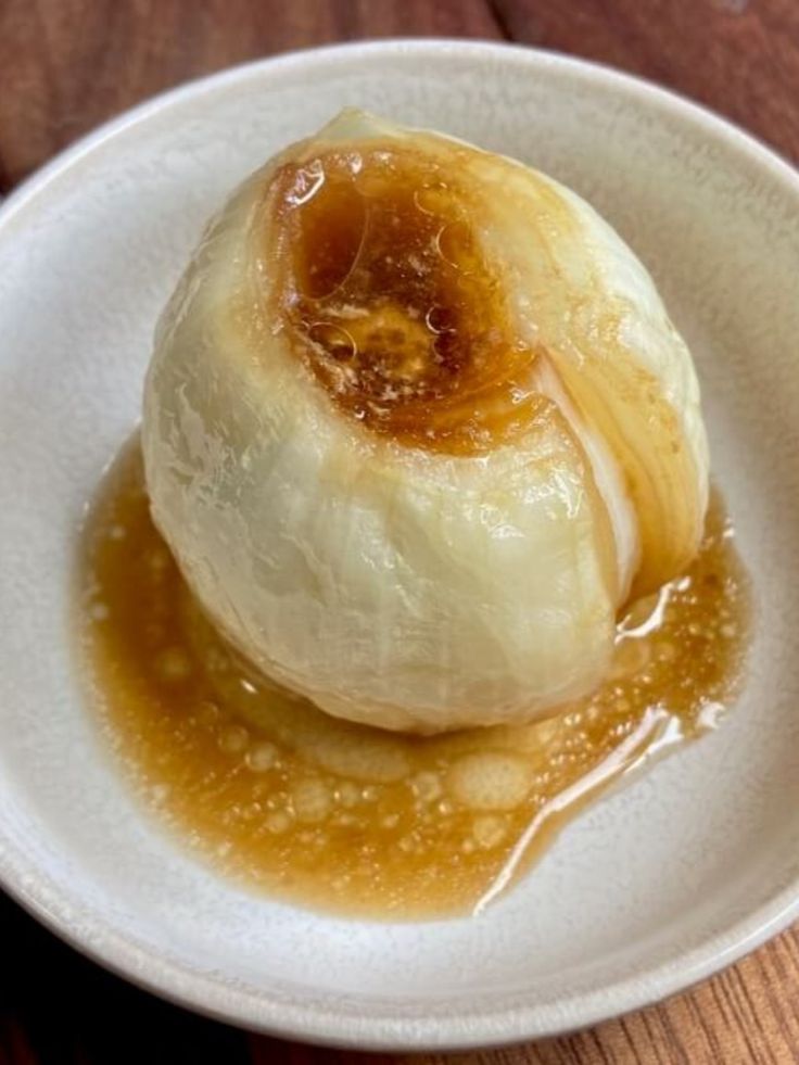 a white bowl filled with food on top of a wooden table