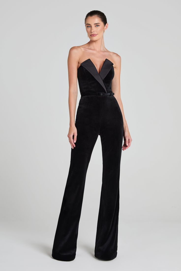 Vivianne Black Jumpsuit Women's Clothing > Jumpsuits. DESCRIPTION &  FEATURES    VIVIANNE is a tuxedo-inspired jumpsuit, crafted from exclusively designed black velvet, with a deep V-neckline. Featuring a structured lapel over the bust, a corseted bodice, our signature fit and flare pant, silhouette-enhancing seam detailing, and functional pockets. Finished with a concealed zip closure and detachable black velvet belt.     Pair it with the      HETTIE Bodysuit    to complete the look.    - Black Nadine Merabi, Structured Corset, Womens Black Jumpsuit, Velvet Belt, Black Velvet Fabric, Corset Boning, Coverall Jumpsuit, Velvet Flares, Flare Jumpsuit