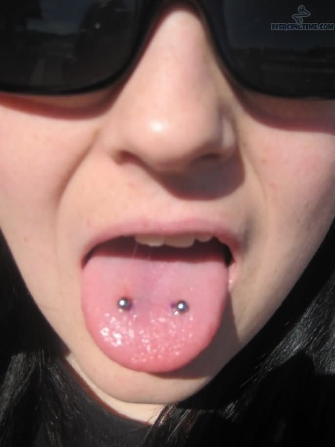 a close up of a person wearing sunglasses with a tongue sticking out