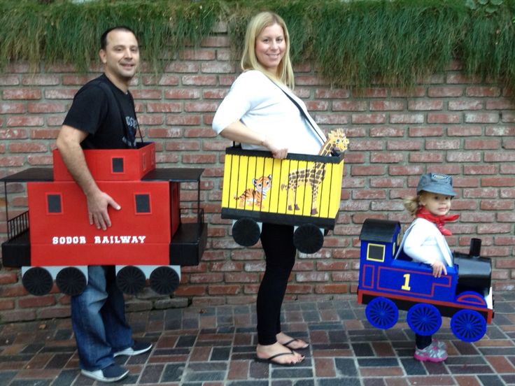 two adults and a child are dressed up as thomas the train