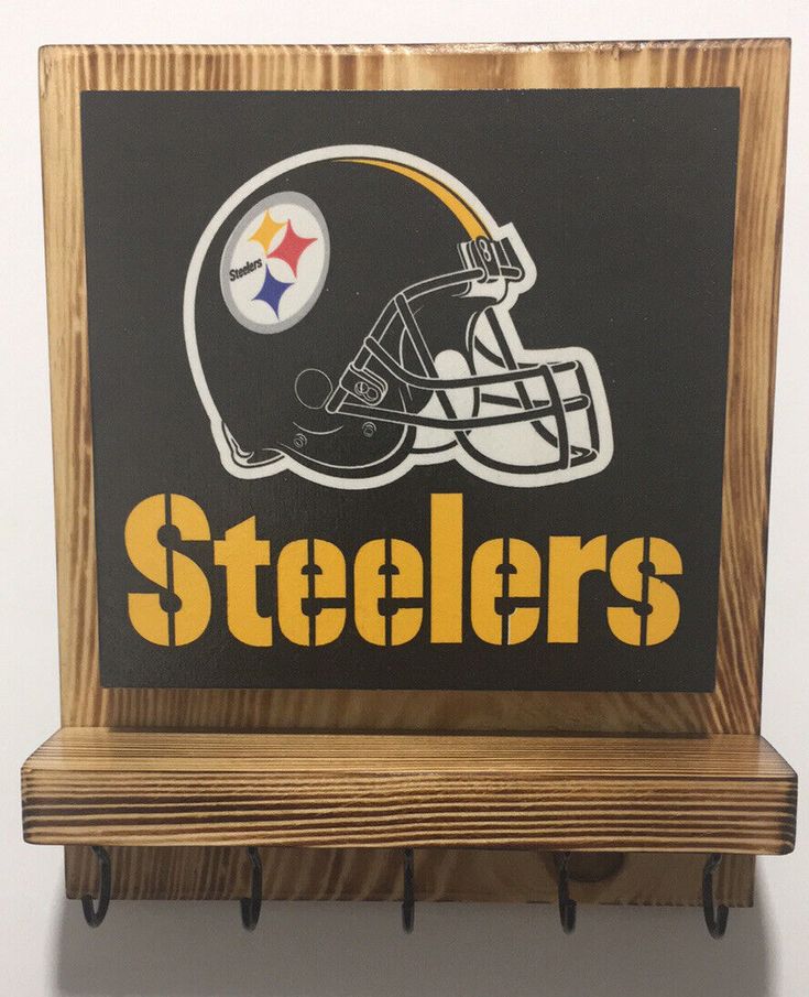 a wooden shelf with a pittsburgh football helmet on it