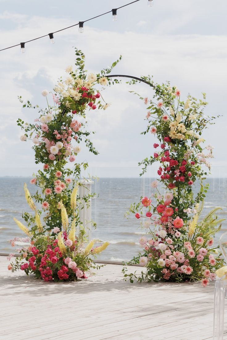 an outdoor ceremony setup with flowers and lights