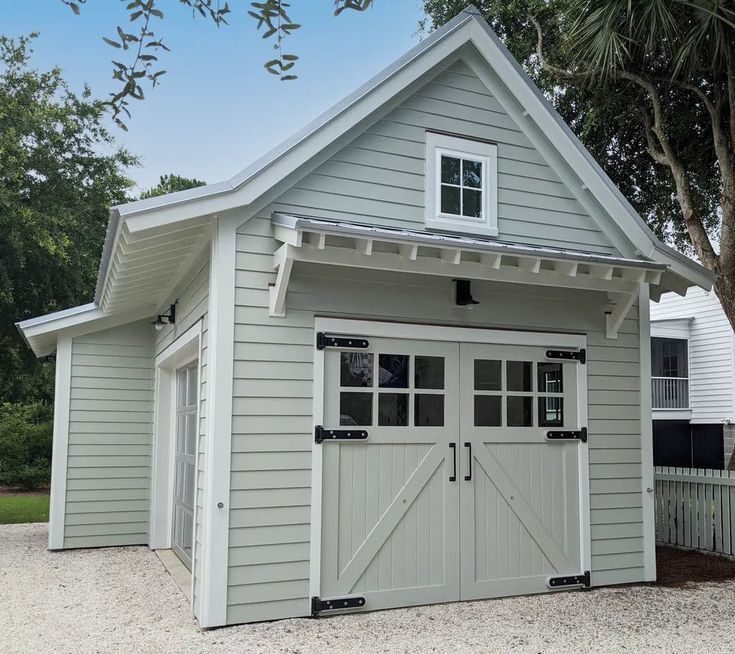 a gray garage with two doors and windows