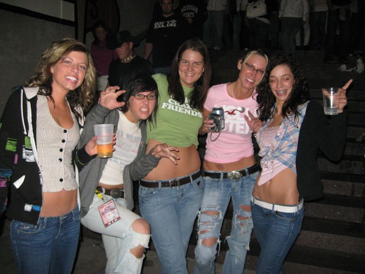 a group of women standing next to each other in front of stairs with beer glasses