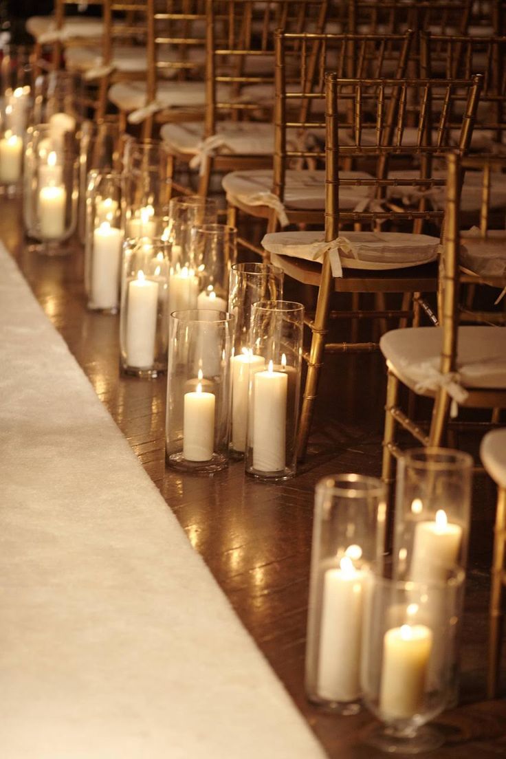 rows of chairs lined up with lit candles