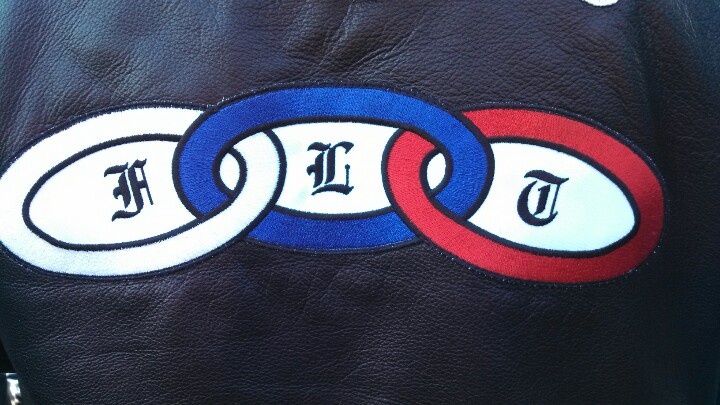 the back of a leather jacket with two rings and letters on it that say,