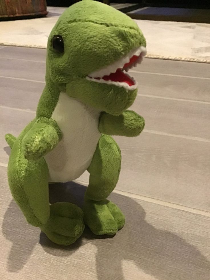 a green stuffed toy with a shark's teeth