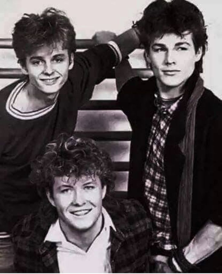 three young men posing for a black and white photo