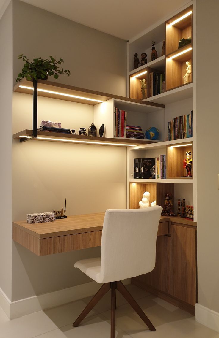 a desk and chair in a room with built - in bookshelves on the wall