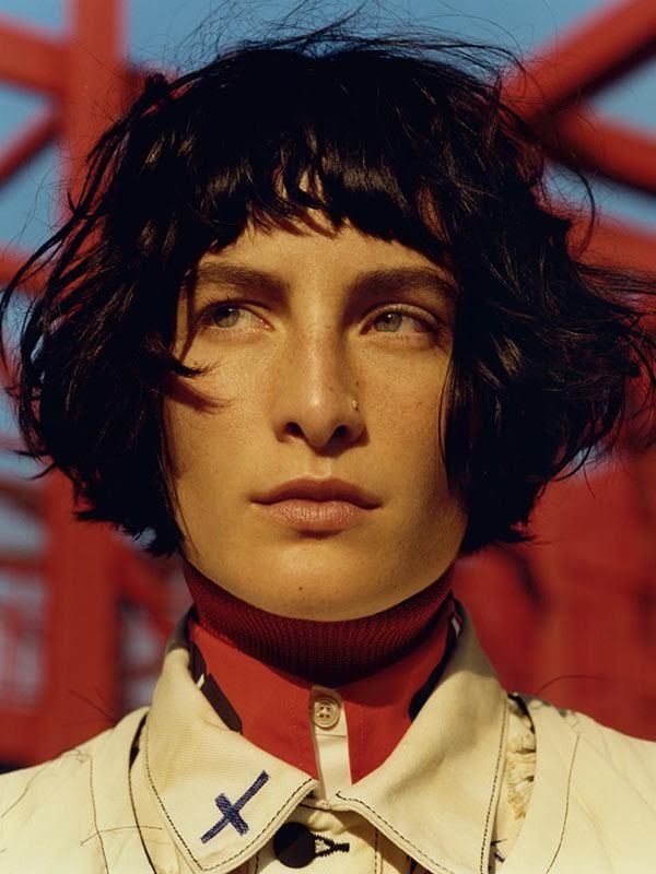 a woman with black hair wearing a white shirt and red necktie, looking at the camera