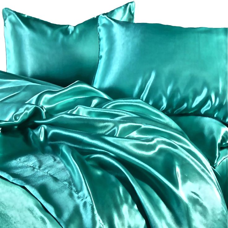 a bed covered in green sheets and pillows