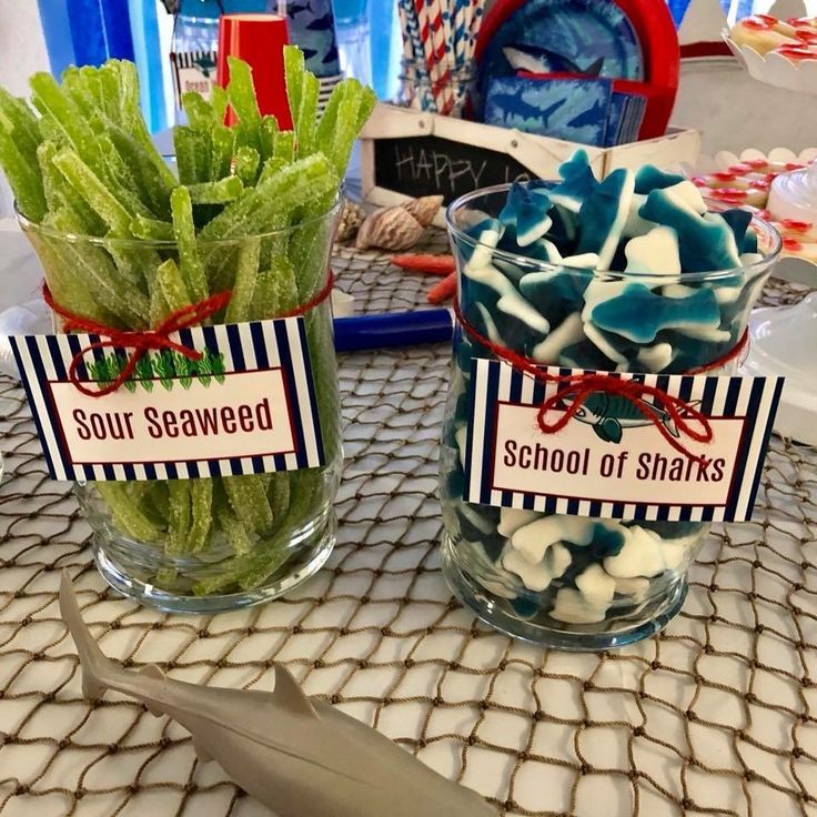 two glass vases filled with green and blue food on top of a table next to each other