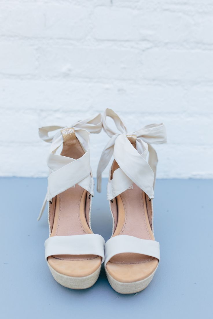 a pair of white shoes with bows on them