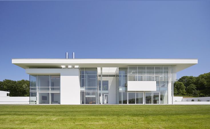 a large white building sitting on top of a lush green field