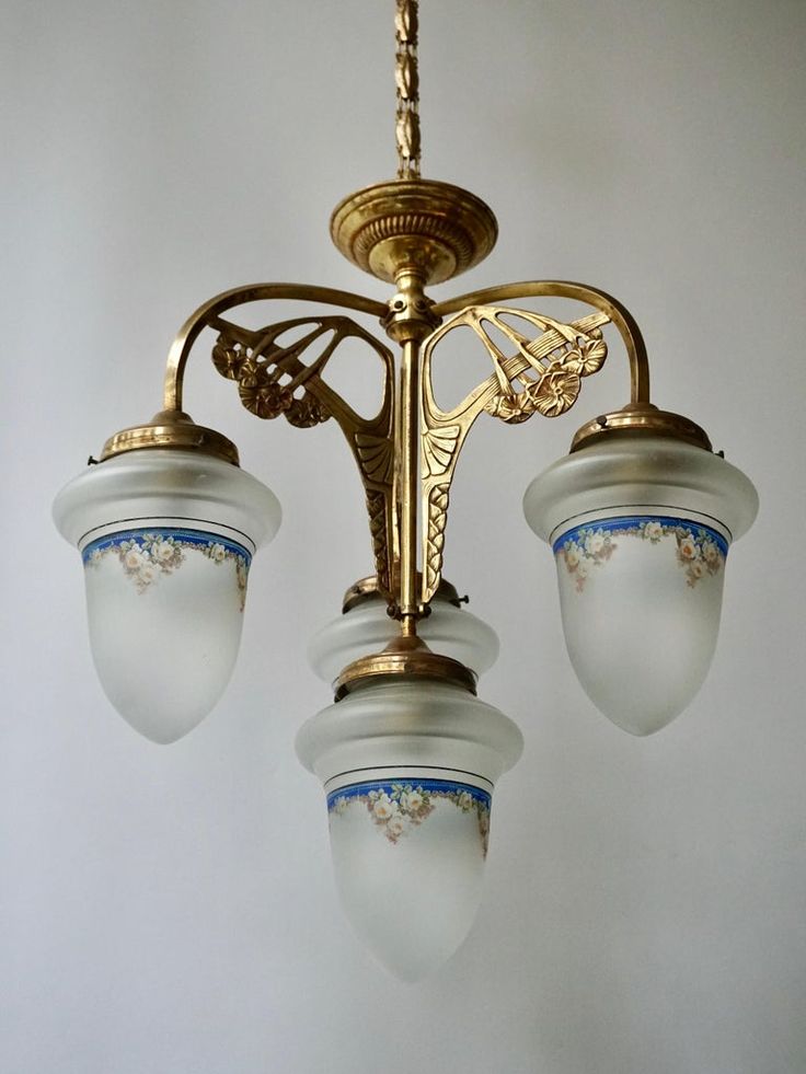 a chandelier with three lights hanging from it's sides in a room