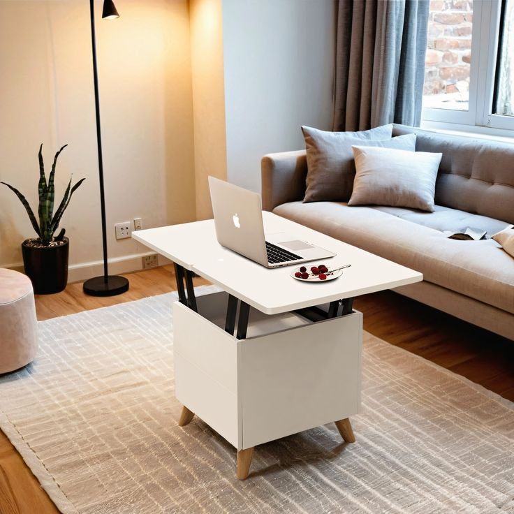 a laptop computer sitting on top of a white table next to a couch in a living room