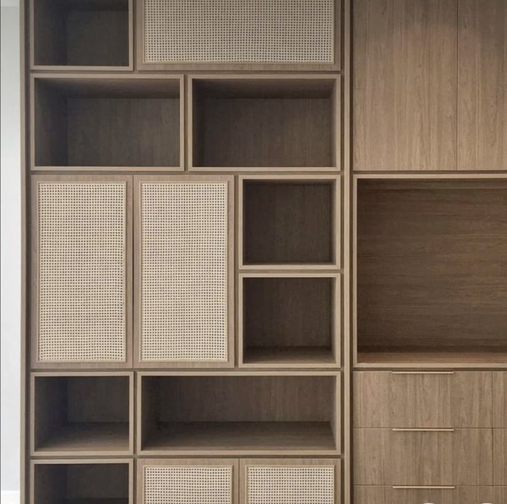 an open bookcase with drawers and baskets on the bottom shelf in front of it