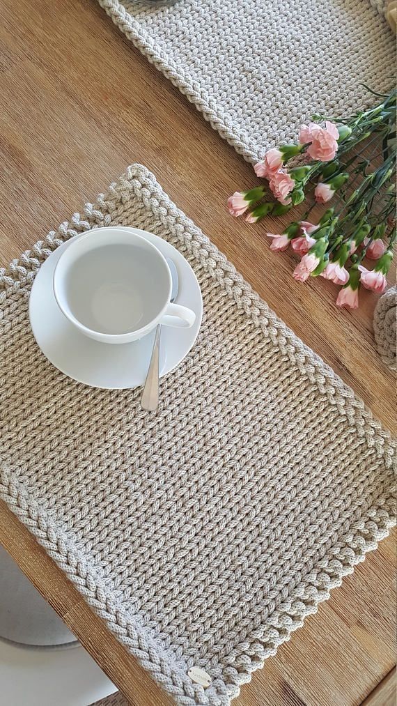 a place mat with a cup and saucer sitting on top of a wooden table