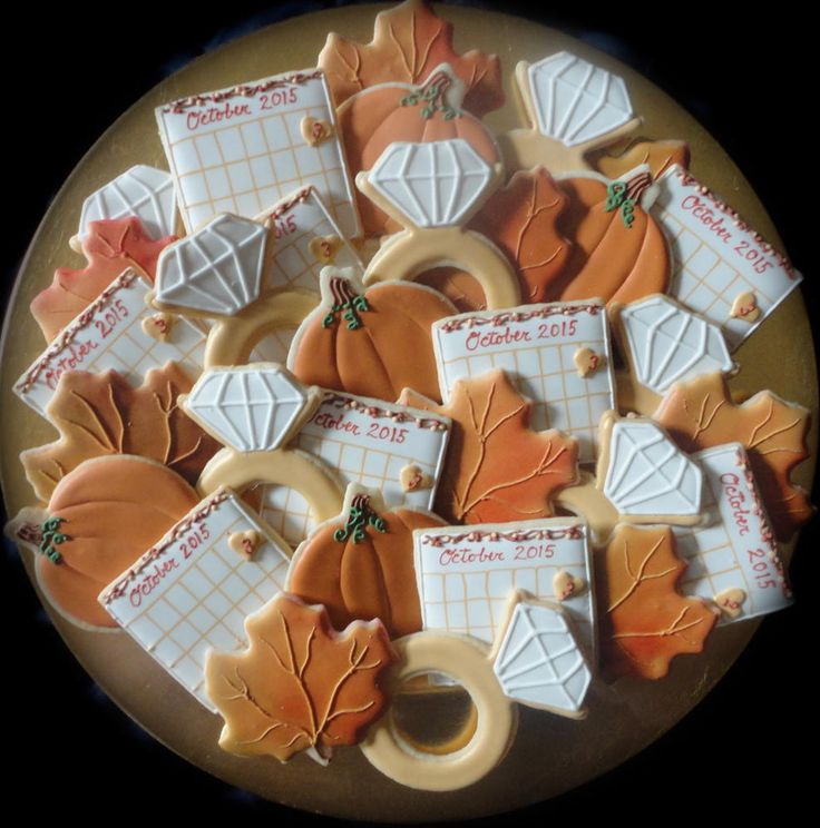 decorated cookies are arranged on a plate with fall leaves and napkins in the center