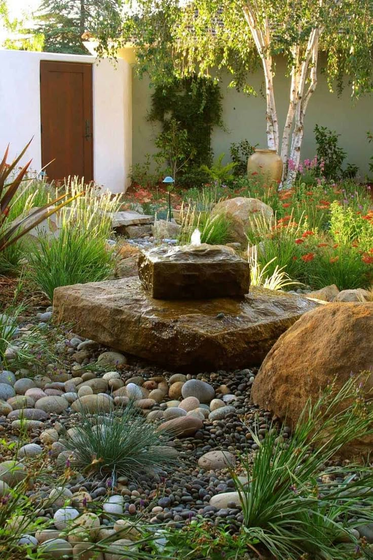 a garden with rocks and plants around it