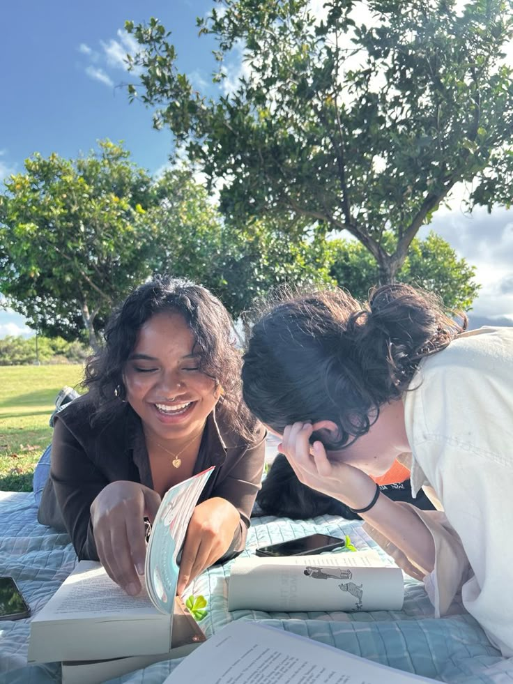 two women looking at an open book together