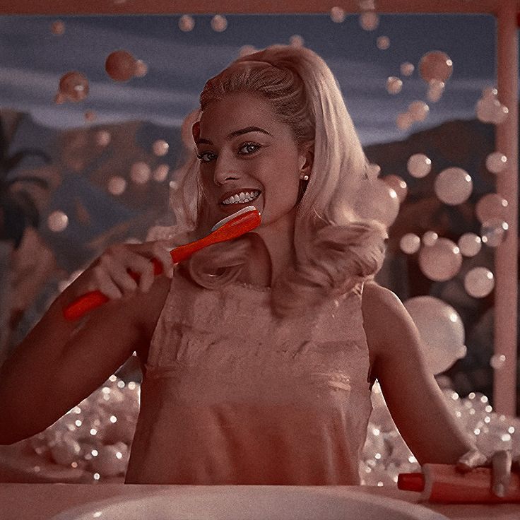 a woman brushing her teeth while standing in front of a mirror with soap bubbles all over it