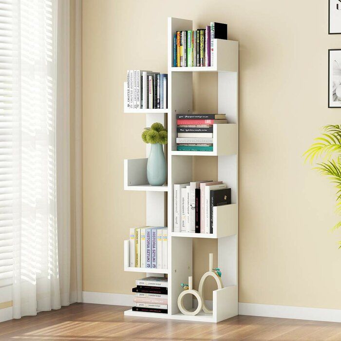 a bookshelf in the corner of a room next to a potted plant