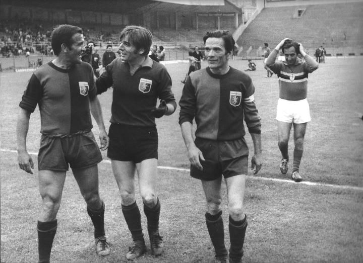 three soccer players are walking on the field