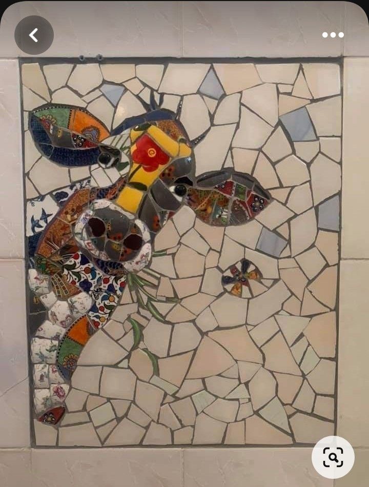 a mosaic tile wall hanging on the side of a building