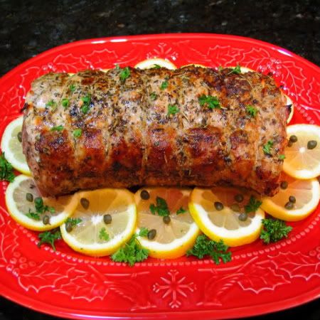 a red plate topped with meat and lemon slices