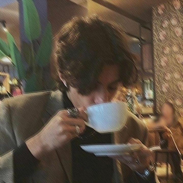 a man drinking out of a white cup