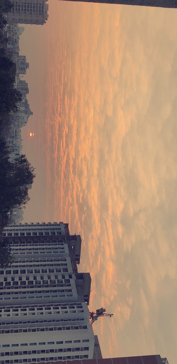 the sky is reflected in the water near tall buildings