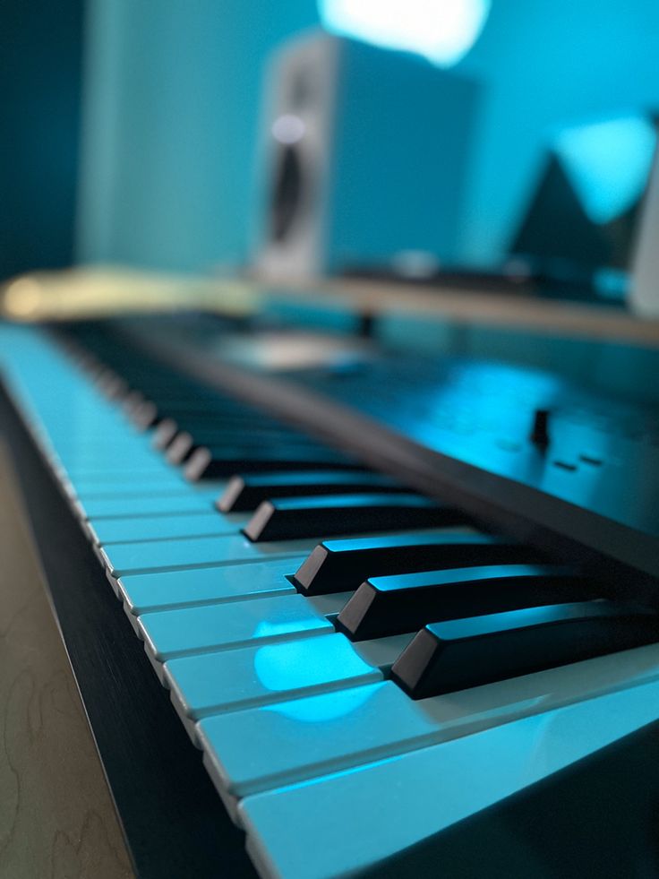 a close up view of the keys on an electronic keyboard with blue light coming from behind it