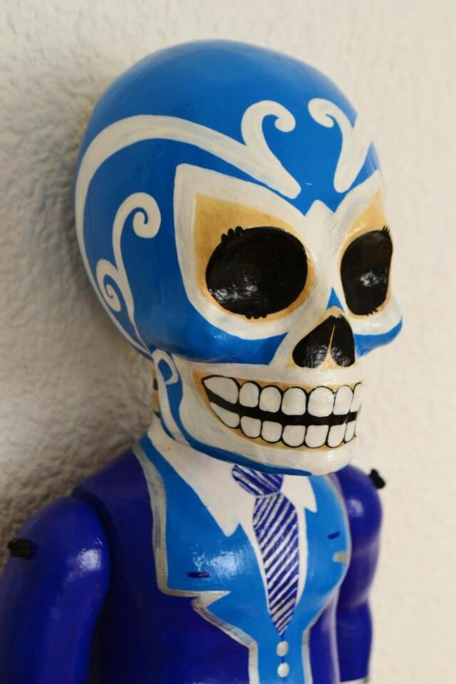 a blue and white skeleton figurine wearing a suit