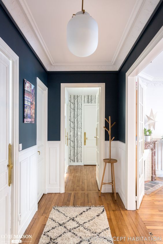 an empty hallway with blue walls and white trim on the door, wood flooring