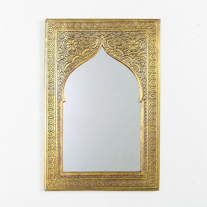 an ornate gold framed mirror against a white wall